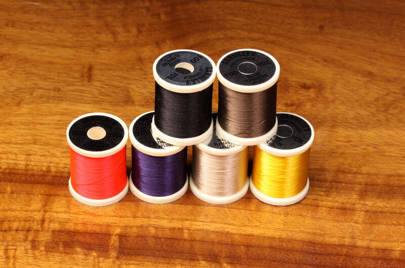 Close-up of 140 Denier Danville thread spool from Clouser's Fly Shop, showing dark brown thread on a white background.