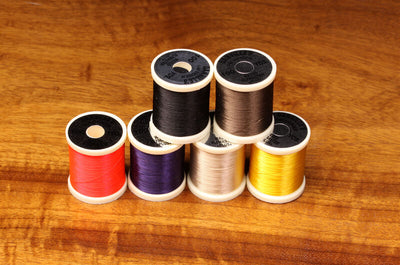 Close-up of 140 Denier Danville thread spool from Clouser's Fly Shop, showing dark brown thread on a white background.