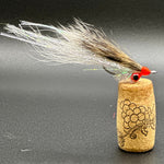 Fishing fly with cork base on a dark surface