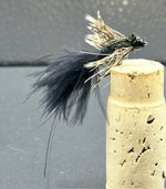 Fly fishing lure with feathers on a cork stopper against a gray background