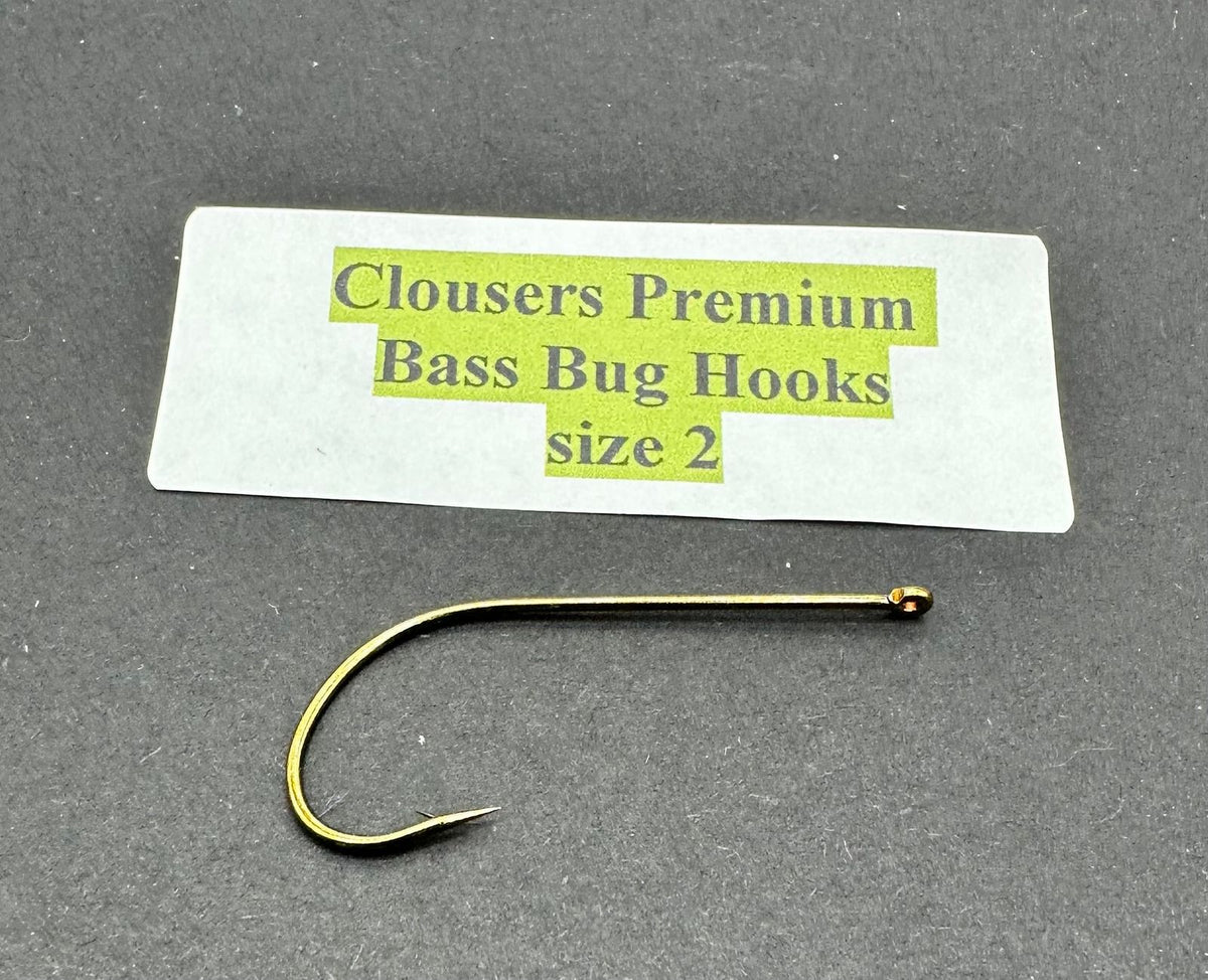 Close-up of Clouser's Premium Bass Bug Hooks, sharp metal hooks designed for bass fishing, displayed on a plain background.