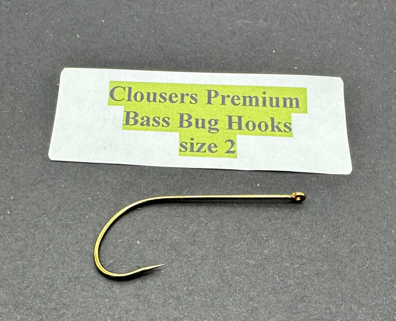 Close-up of Clouser's Premium Bass Bug Hooks, sharp metal hooks designed for bass fishing, displayed on a plain background.