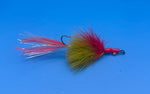 Red and yellow fly fishing lure against a blue background
