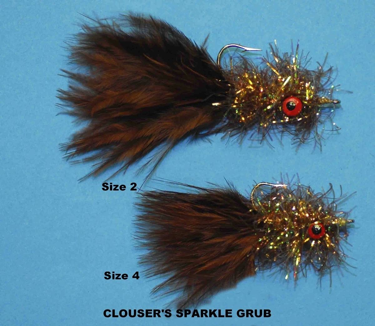 Hand-tied Clouser's Sparkle Grubb fly by Bob Clouser with autograph card, showcasing vibrant feathers and fishing lure craftsmanship.