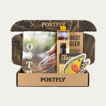 Open box containing fishing equipment with 'POSTFLY' branding on a light gray background
