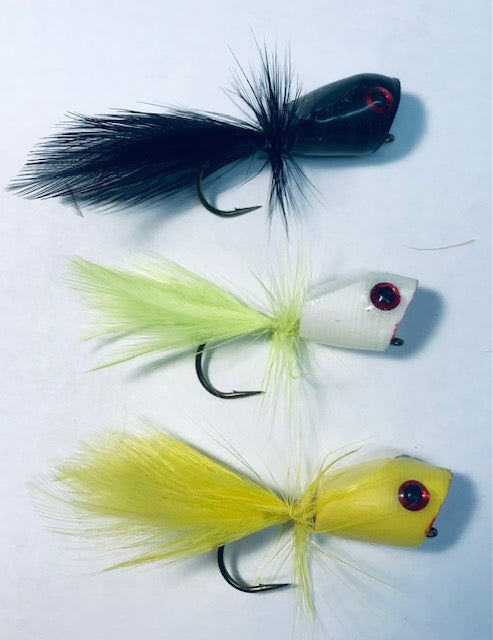 Three fishing flies with different colors and designs on a white background