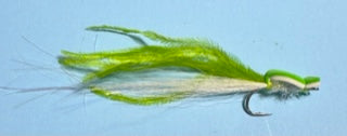 Green and white fly fishing lure on a blue background