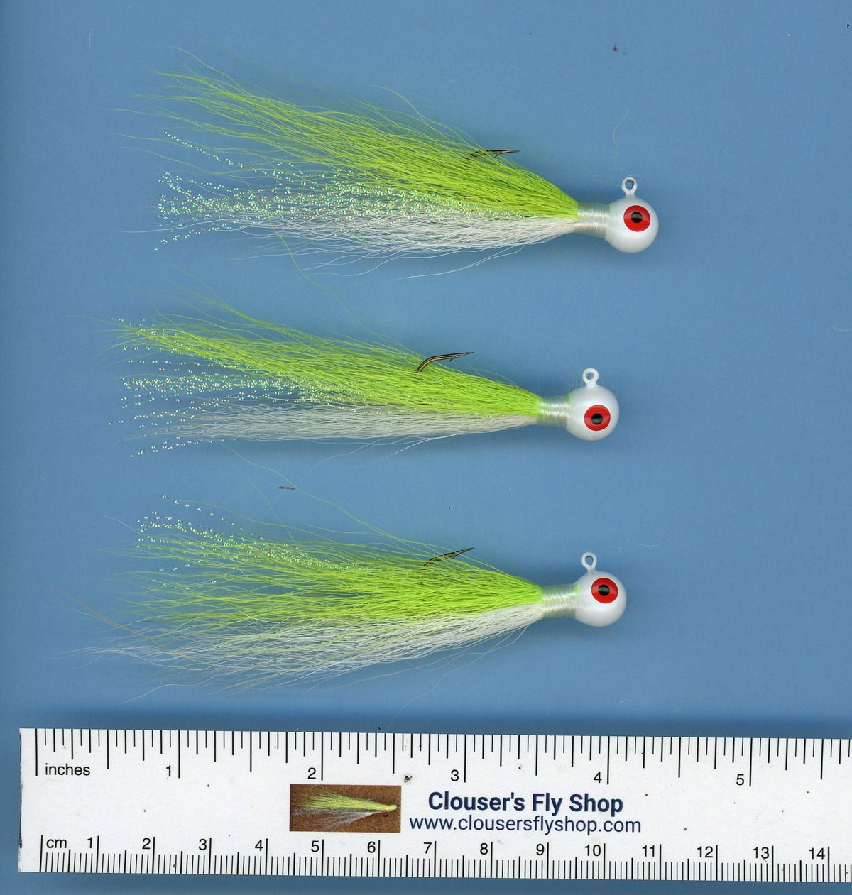 Three 1/4 oz Bucktail Jigs with painted heads and eyes, designed for fishing, by Clouser's Fly Shop.
