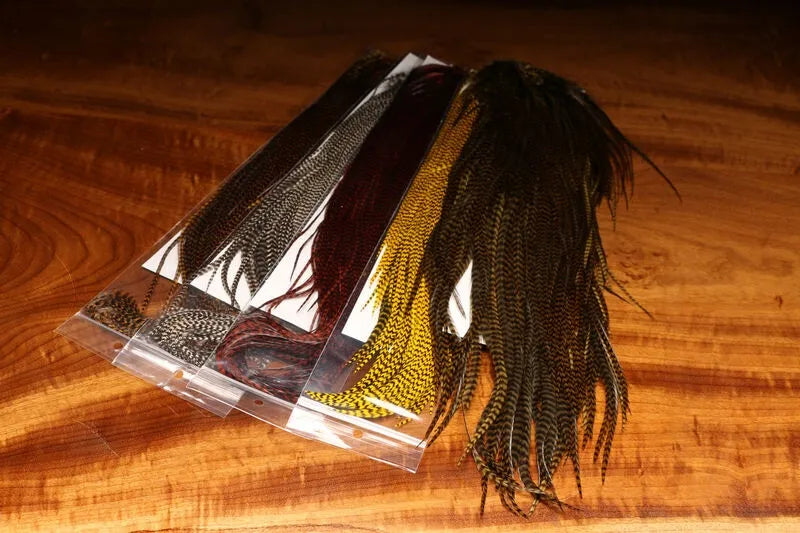Clouser's Fly Shop Keough Grizzly 1/2 Saddles fly tying material, showing textured feathers in natural brown and tan shades.